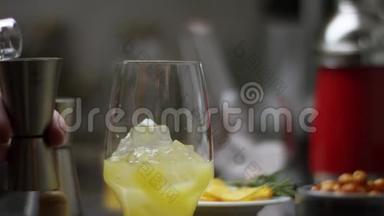 准备橙汁的鸡尾酒酒吧是从冰开始的。 酒保在现代酒吧准备鸡尾酒。 酒吧搅拌